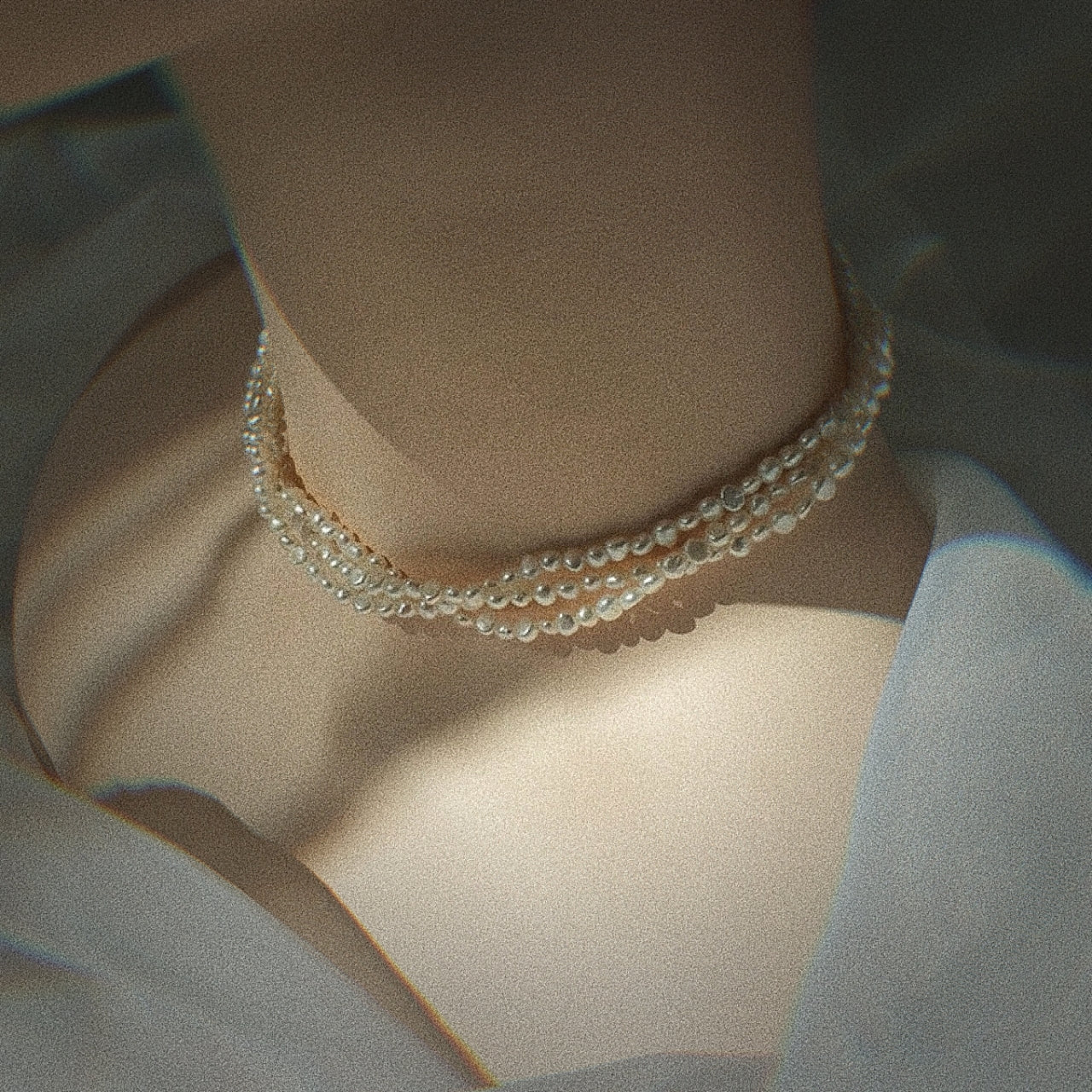a female model wearing triple strand pearl necklace