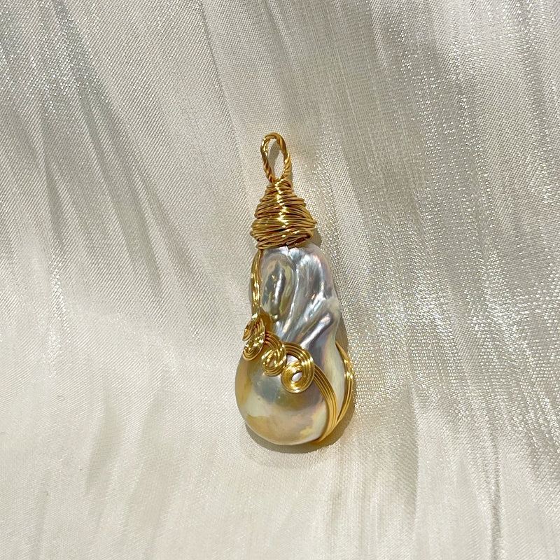 white pearl pendant H on white fabric