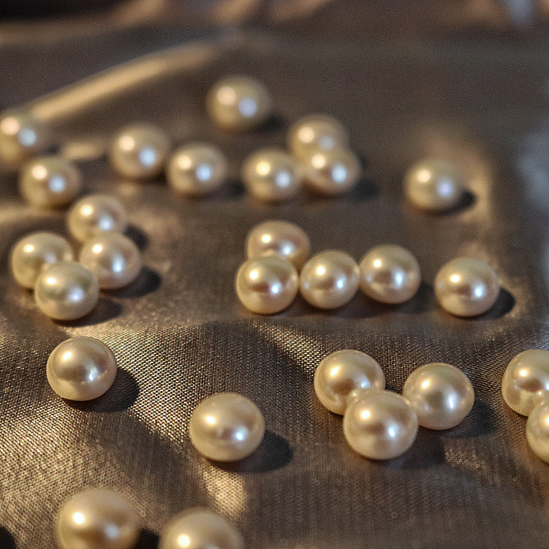 High luster loose pearls on a grey fabric studio image