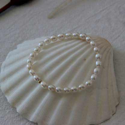 Freshwater Pearl Elastic Bracelet with Golden Bead Deco Sia on a shell Studio Image