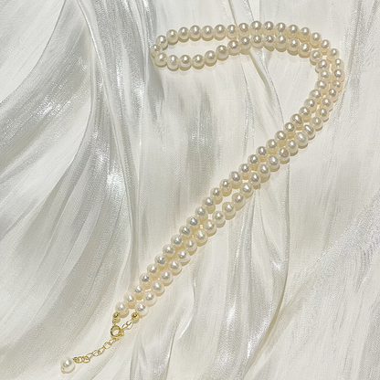 Classic Freshwater Pearl Necklace Anna lying on satin fabric studio image