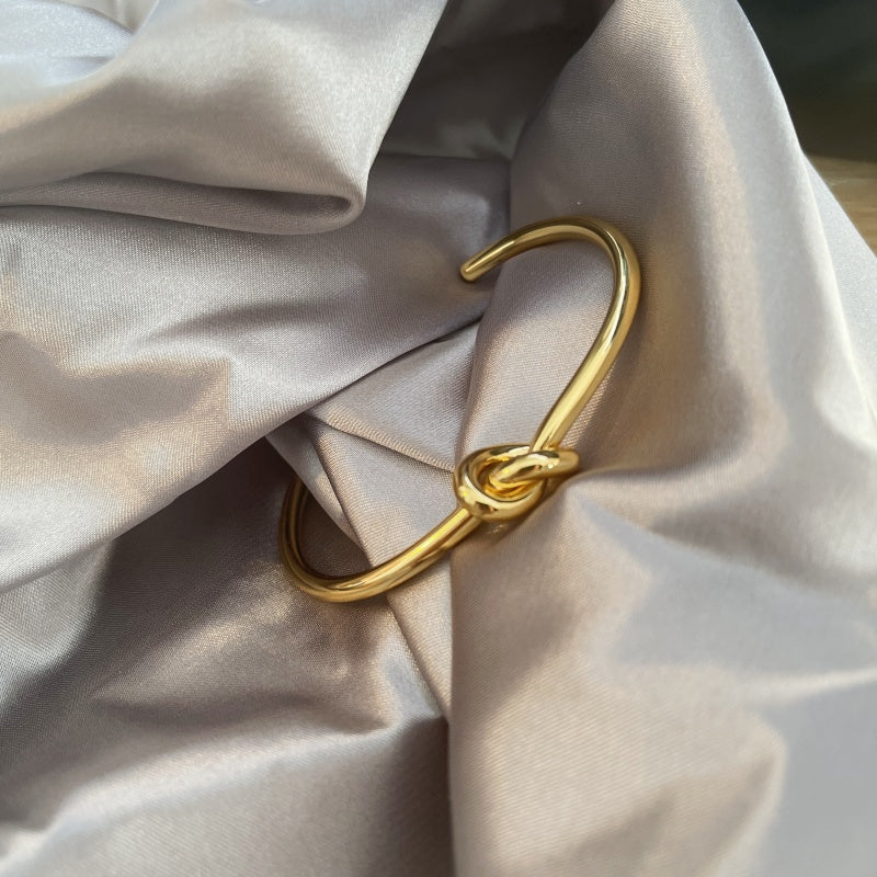 Gold-plated love knot Bangle Bracelet in grey satin background