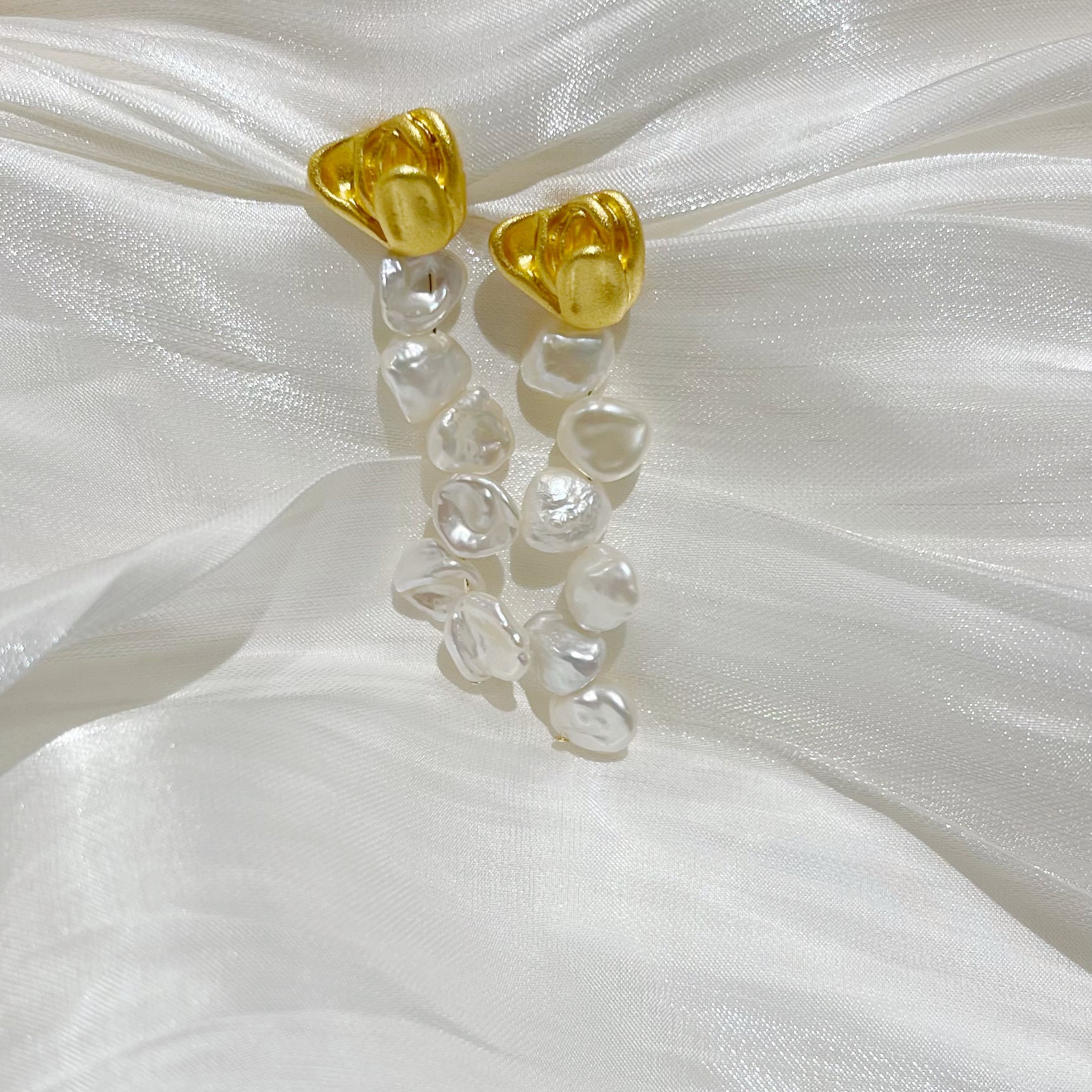 Satin Rose Petal Baroque Sea Pearl Drop Earrings Yolanda on white satin cloth close look studio image