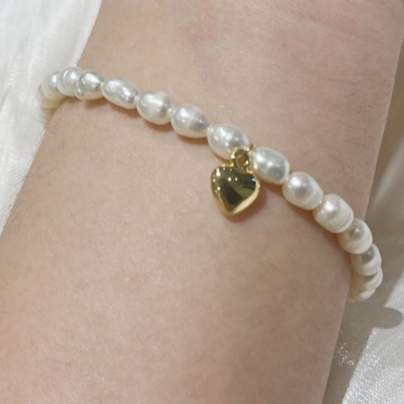 A model wearing Freshwater Pearl Bracelet with Gold Plated Heart Charm Beryl